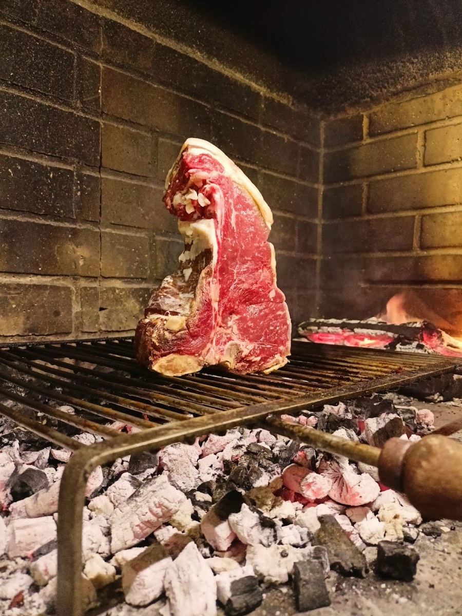 Bistecca sulla brace nel camino a legna